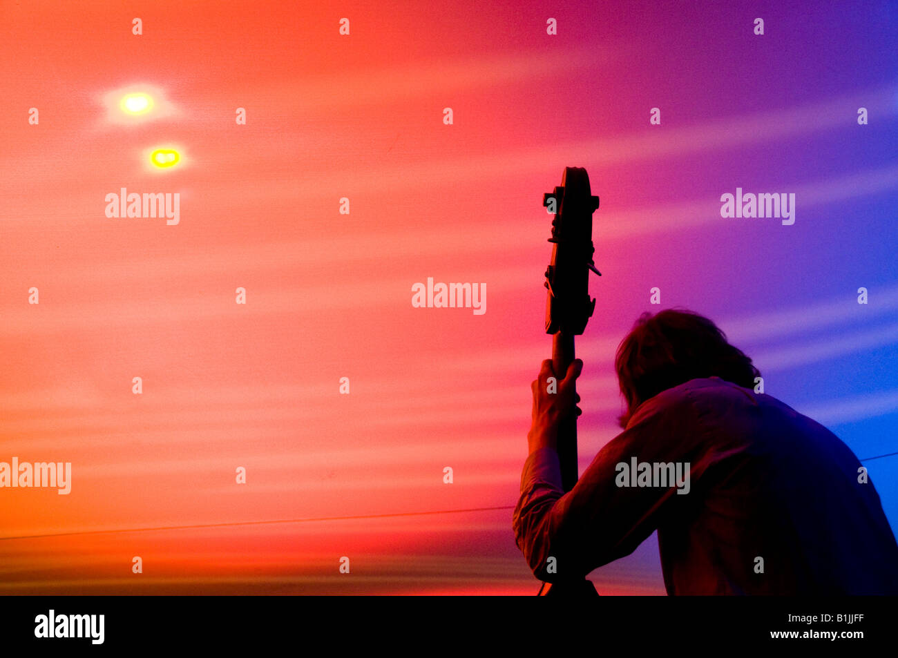 Double bass player musicista jazz suonare sul palco sotto una tettoia multicolore Foto Stock