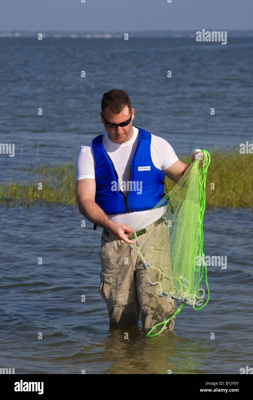 La preparazione di gettare una rete per pesci, North Florida Foto Stock