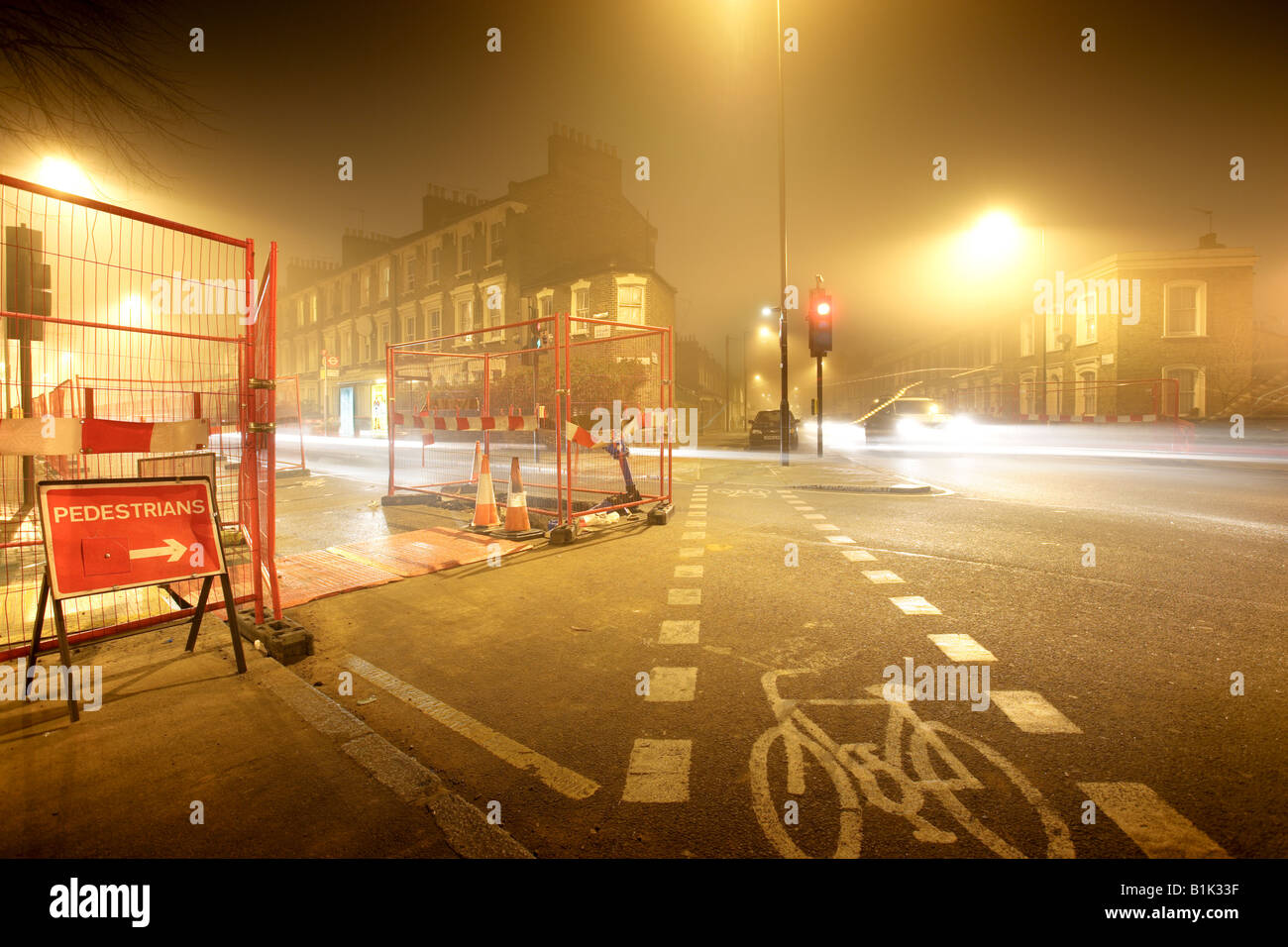 Rad opere corsia bicicletta strada nebbia notte Londra Regno Unito auto streamers Foto Stock