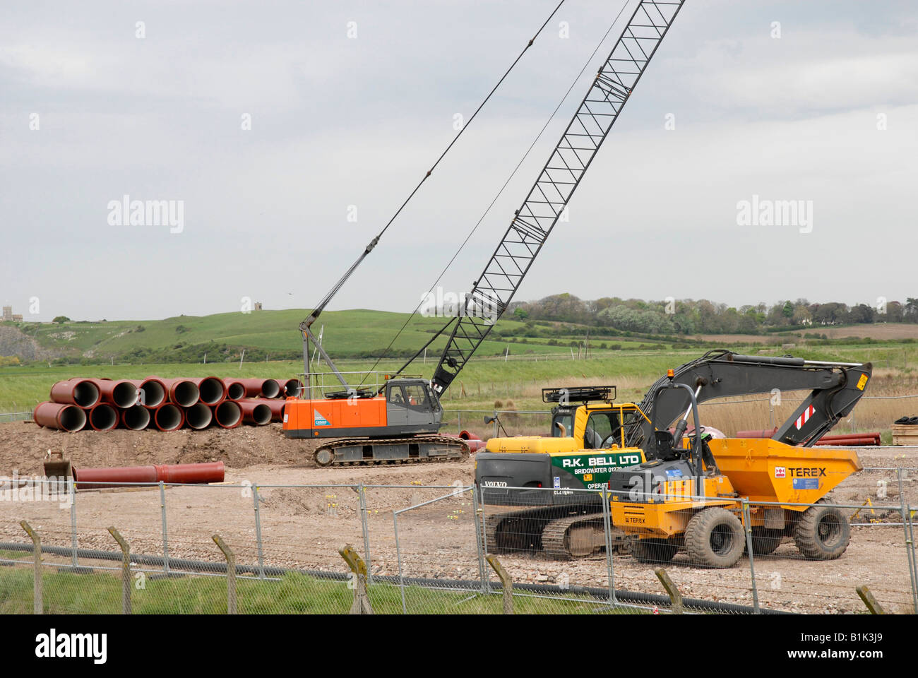 Sito in costruzione, costruzione di gru, digger, tubi, REGNO UNITO Foto Stock