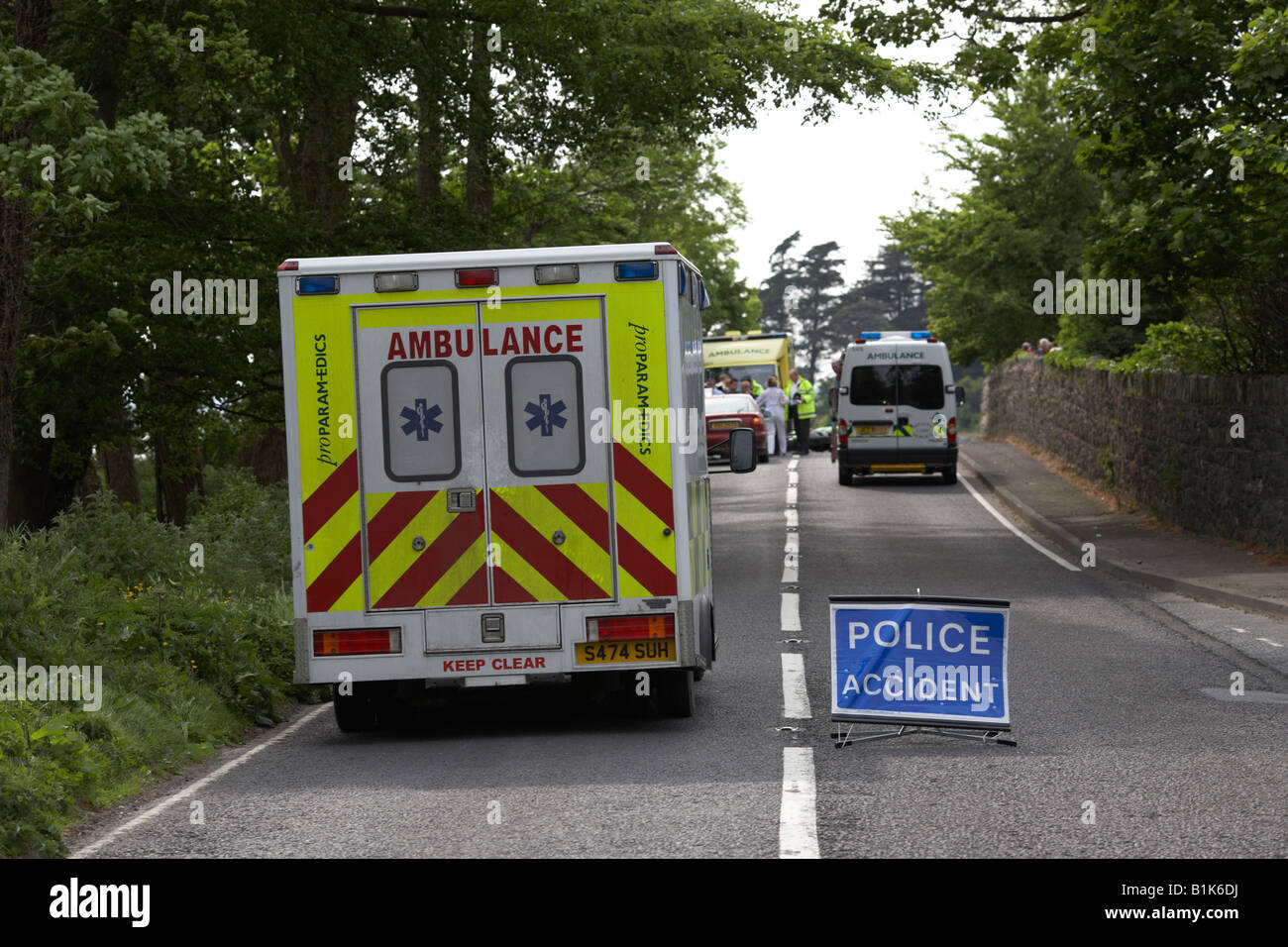 Paramedic ambulanza privato passa la polizia incidente accesso temporaneo a metà della strada sulla scena di un incidente stradale Foto Stock