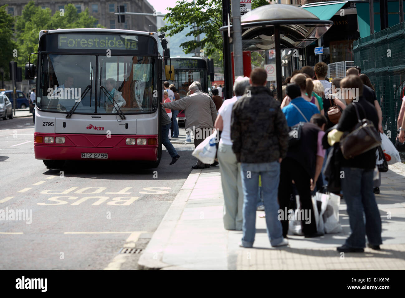 I passeggeri in coda e di salire a bordo di un autobus alla fermata durante il sabato shopping belfast Irlanda del Nord Foto Stock