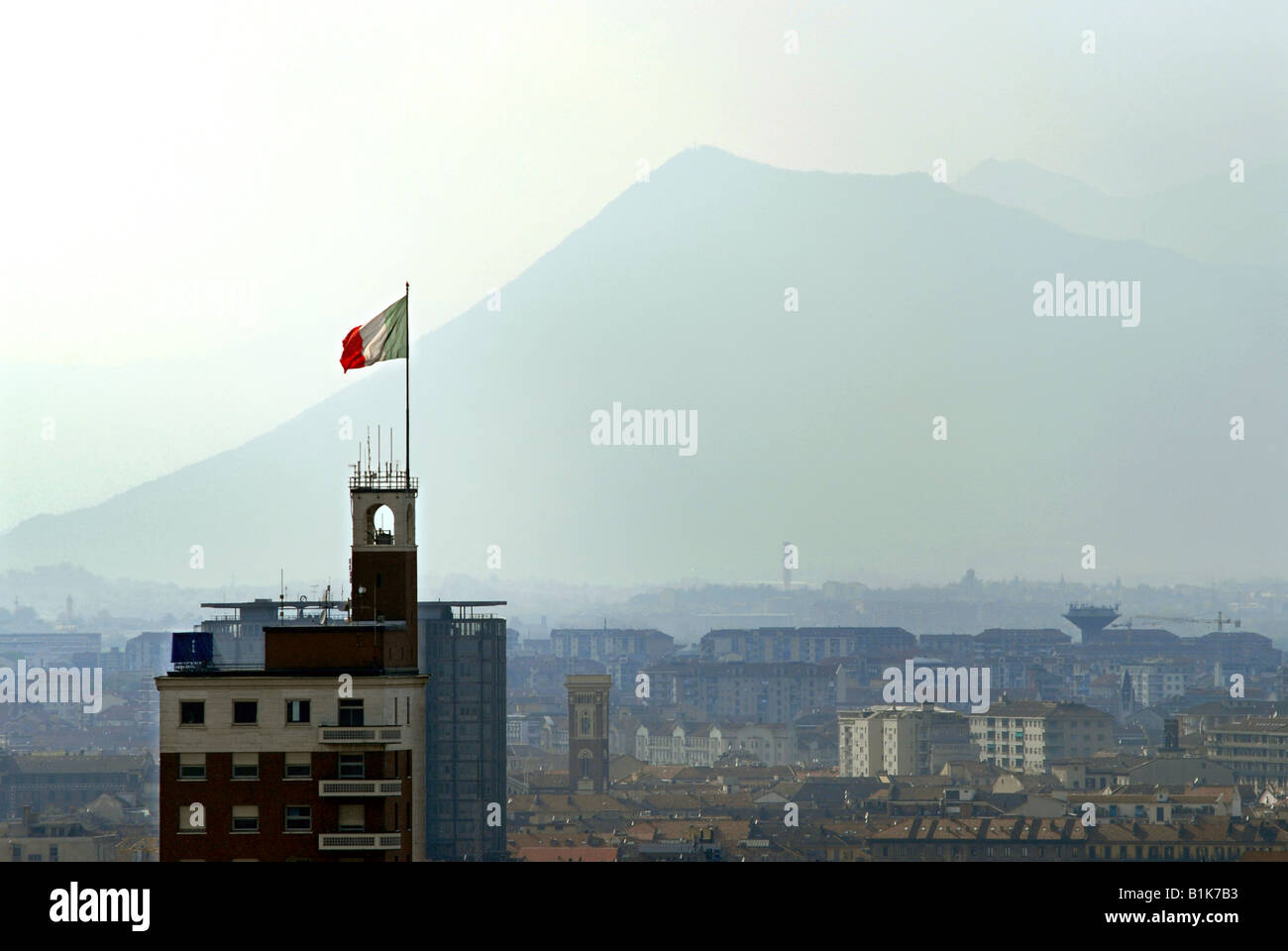 La bandiera italiana, il Tricolore, vola sulla cima di uno degli edifici più alti di Torino, Piemonte, Italia. Foto Stock