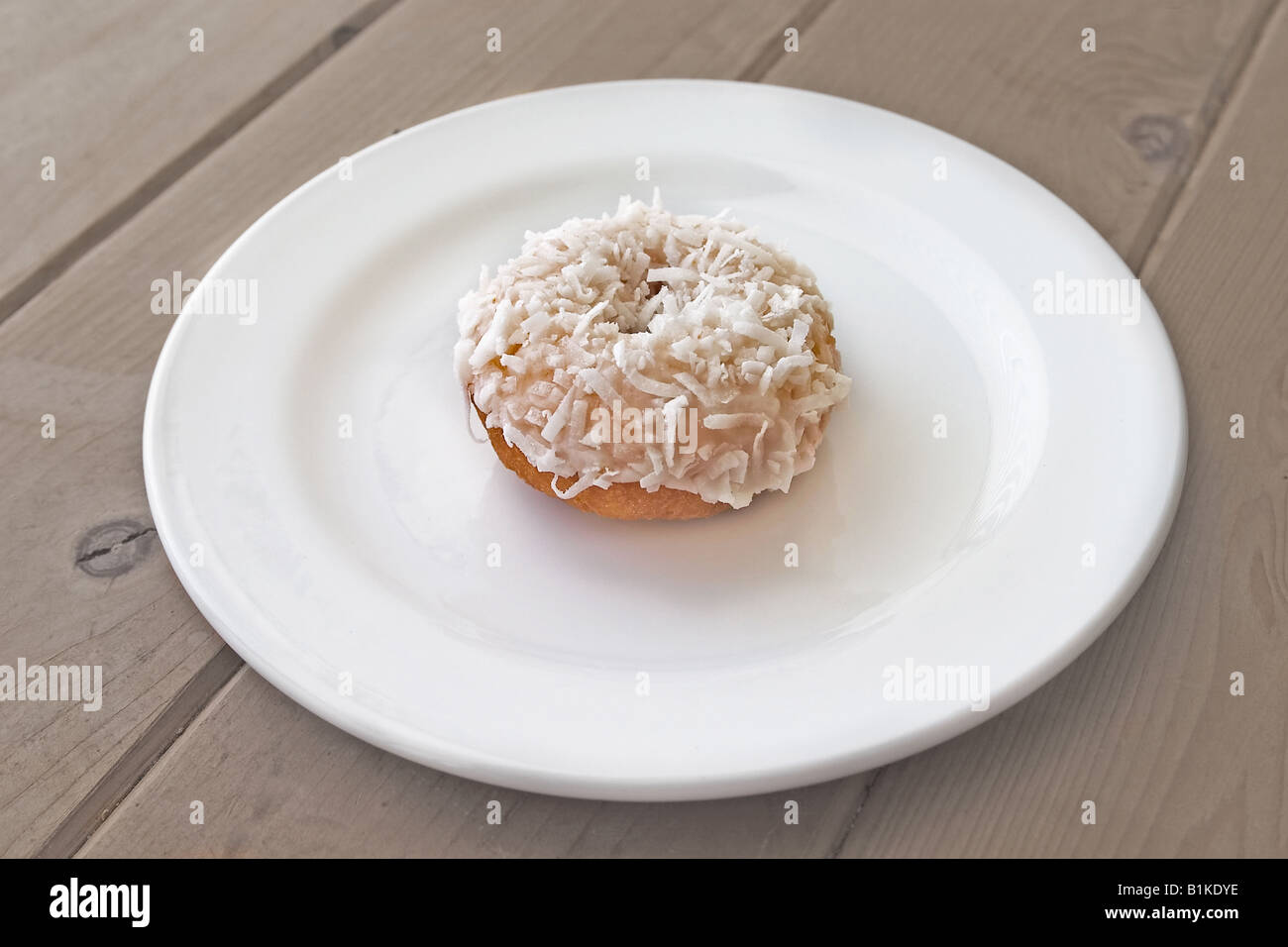 Ciambella con glassa bianca e ricoperti di fiocchi di cocco Foto Stock