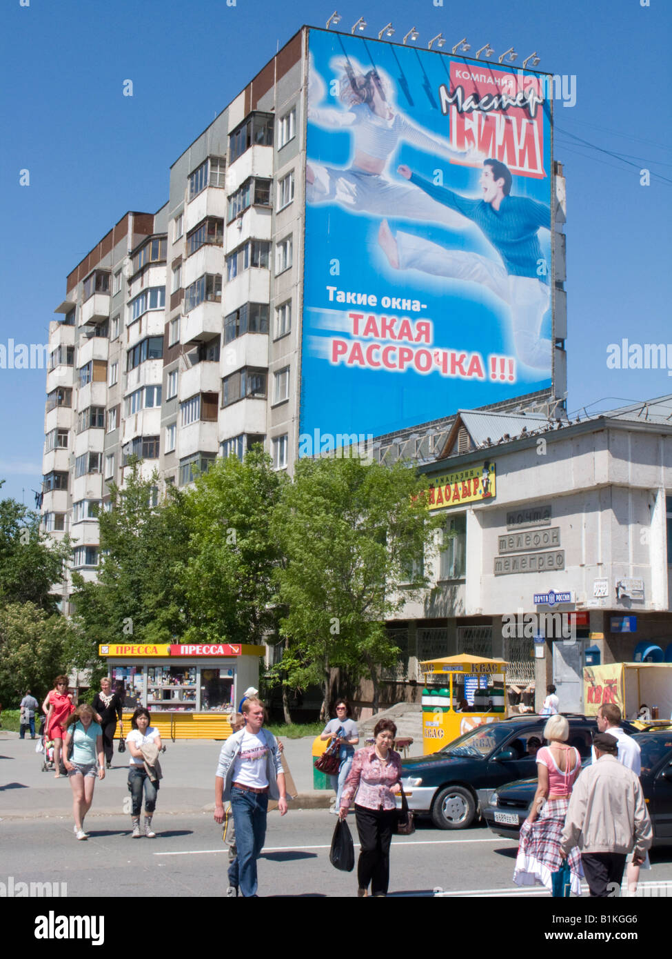 Il contrasto del moderno e grande cartellone pubblicitario sul vecchio era sovietica un blocco di appartamenti in Yuzhno Sakhalinsk Sakhalin in Russia 2008 Foto Stock