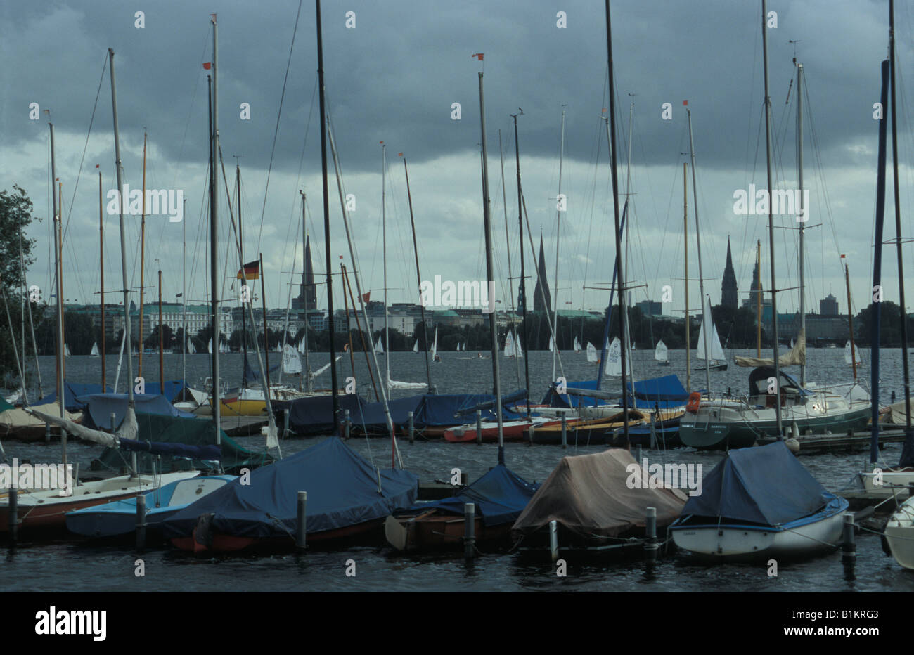 Cielo nuvoloso su barche a vela sul lago Aussenalster e vista sulla parte interna della città di Amburgo, Germania Foto Stock