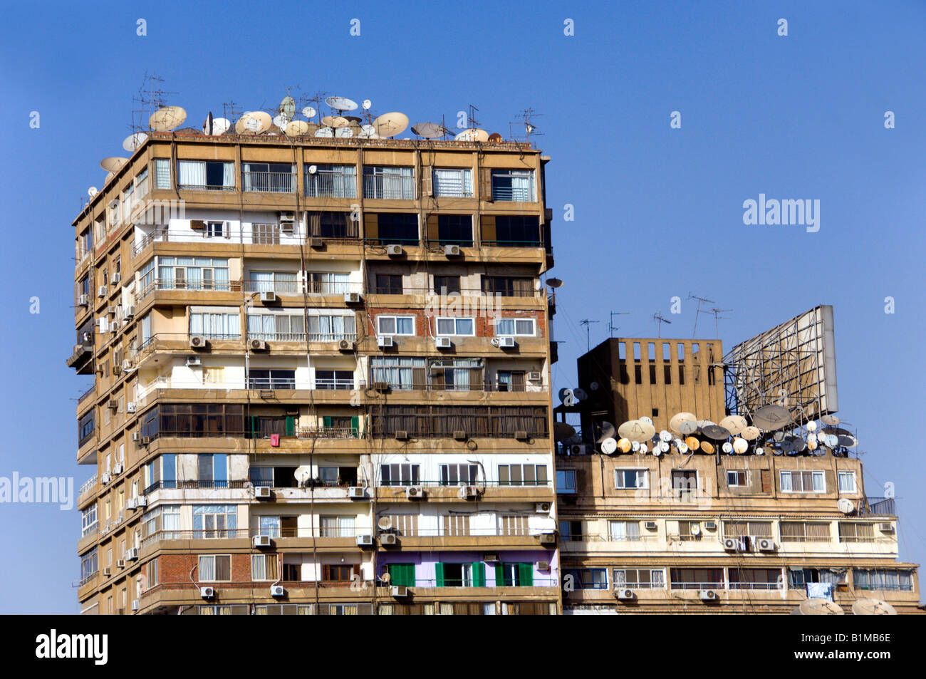 Un alto complesso di appartamenti in Zamalek con tv satellitare piatti su tetti in Il Cairo Egitto Foto Stock