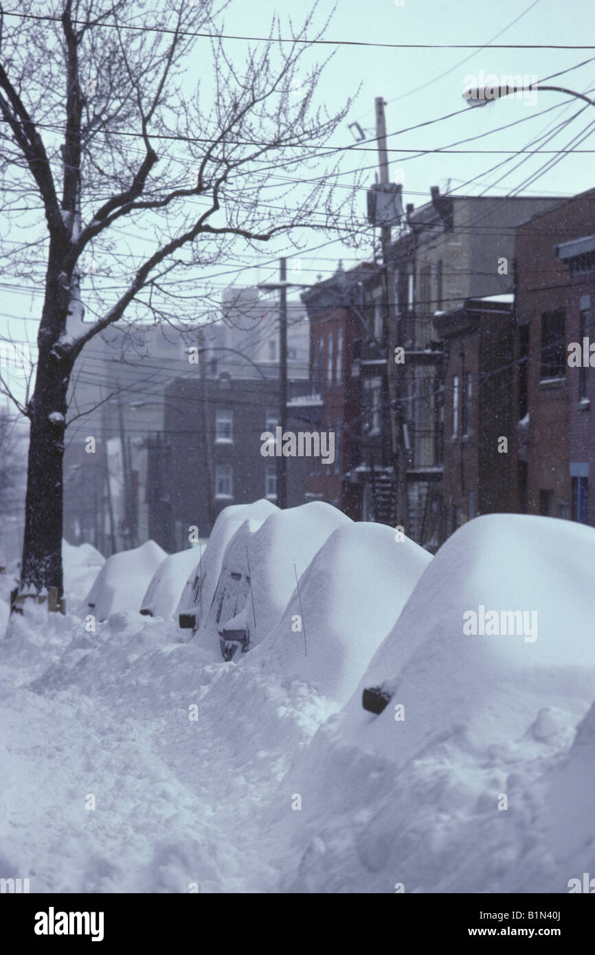 Una tempesta di neve in inverno seppellisce le vetture lungo le strade strette del Plateau Mt. Royal area di Montreal, Quebec, Canada. Foto Stock