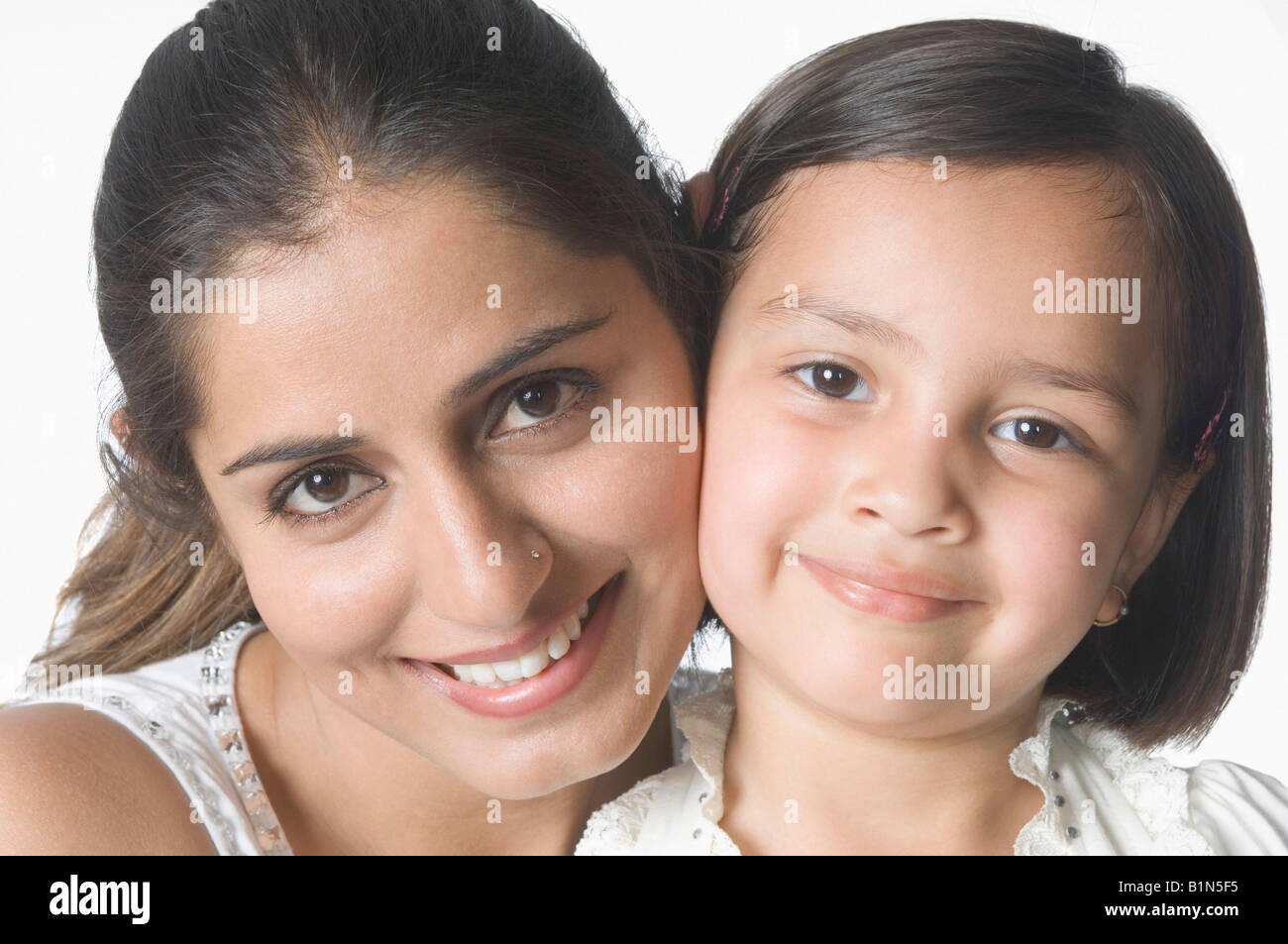 Ritratto di una giovane donna guancia a guancia con sua figlia e sorridente Foto Stock