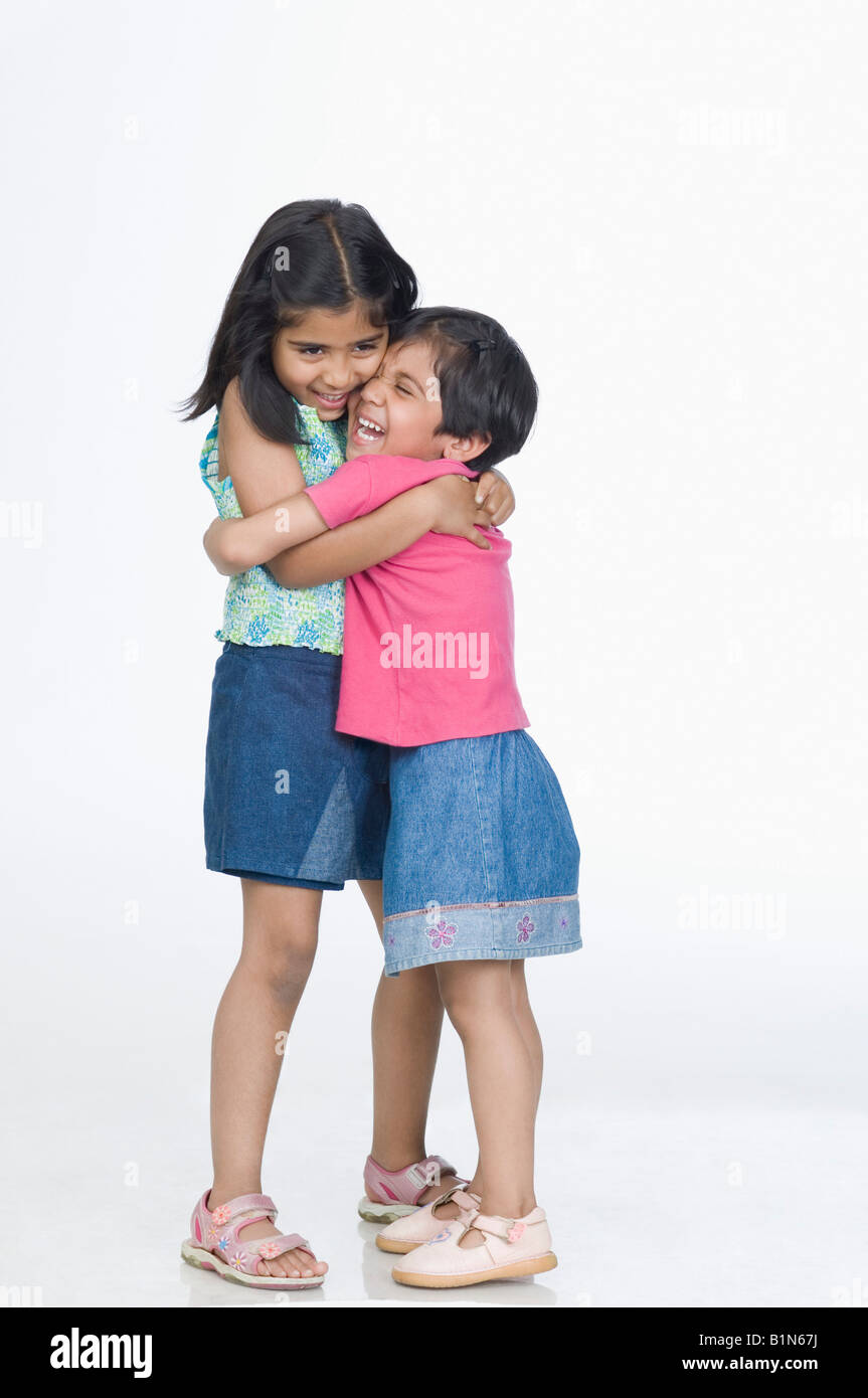 Due ragazze che abbraccia ogni altra e sorridente Foto Stock