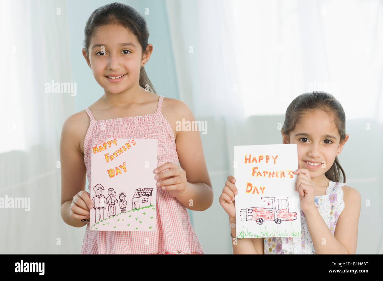 Ritratto di due ragazze che mostrano i loro disegni e sorridente Foto Stock