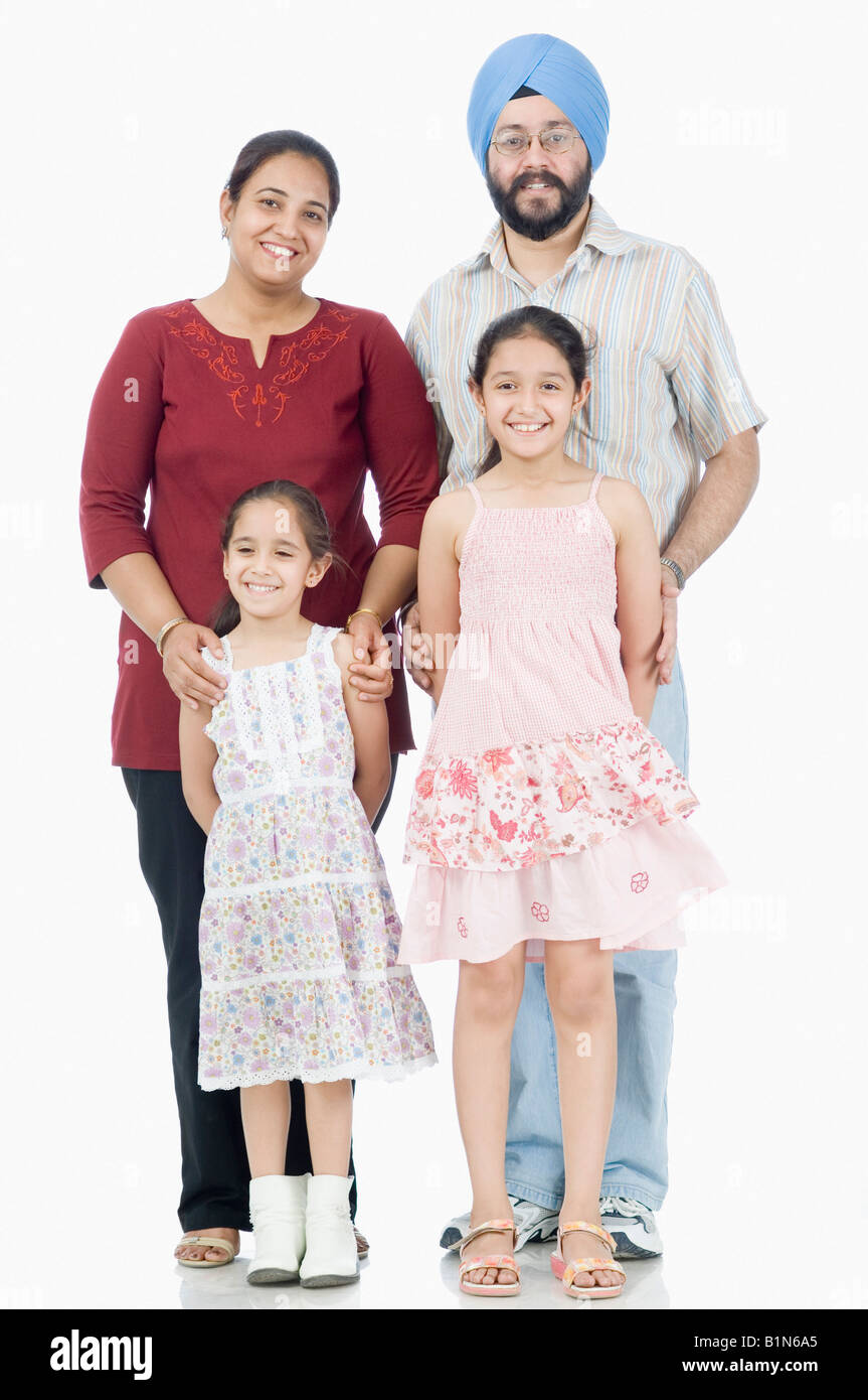 Ritratto di una metà adulto giovane con le loro due figlie insieme permanente Foto Stock