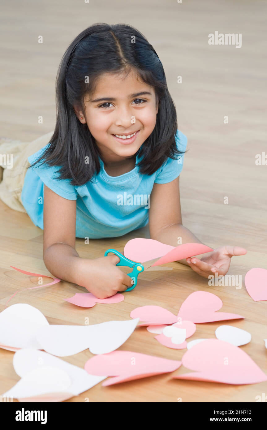 Ritratto di una ragazza carte di taglio a forma di cuore e sorridente Foto Stock