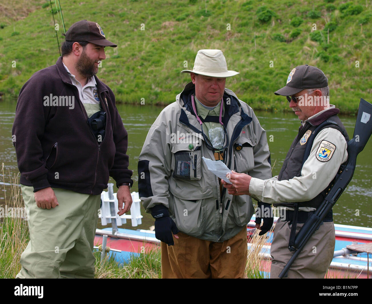 US Federal pesci e fauna selvatica ufficiali controllare Fisherman's licenza di pesca. Foto Stock