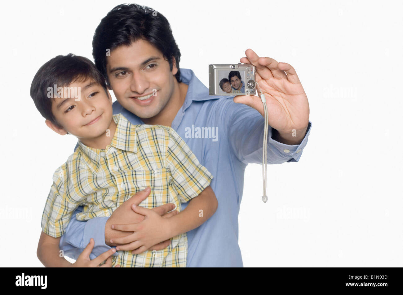 Giovane uomo e suo figlio di prendere una fotografia di se stessi con una fotocamera digitale Foto Stock