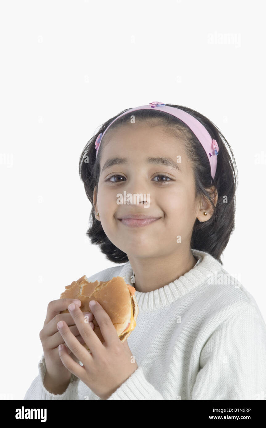 Ritratto di una ragazza di mangiare un hamburger Foto Stock