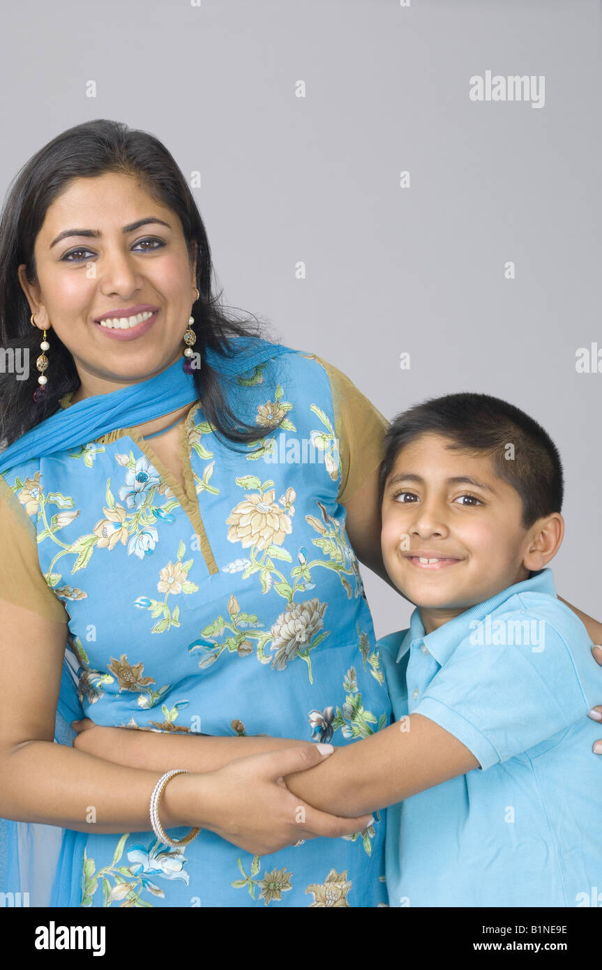Ritratto di un ragazzo abbraccia il suo madre e sorridente Foto Stock