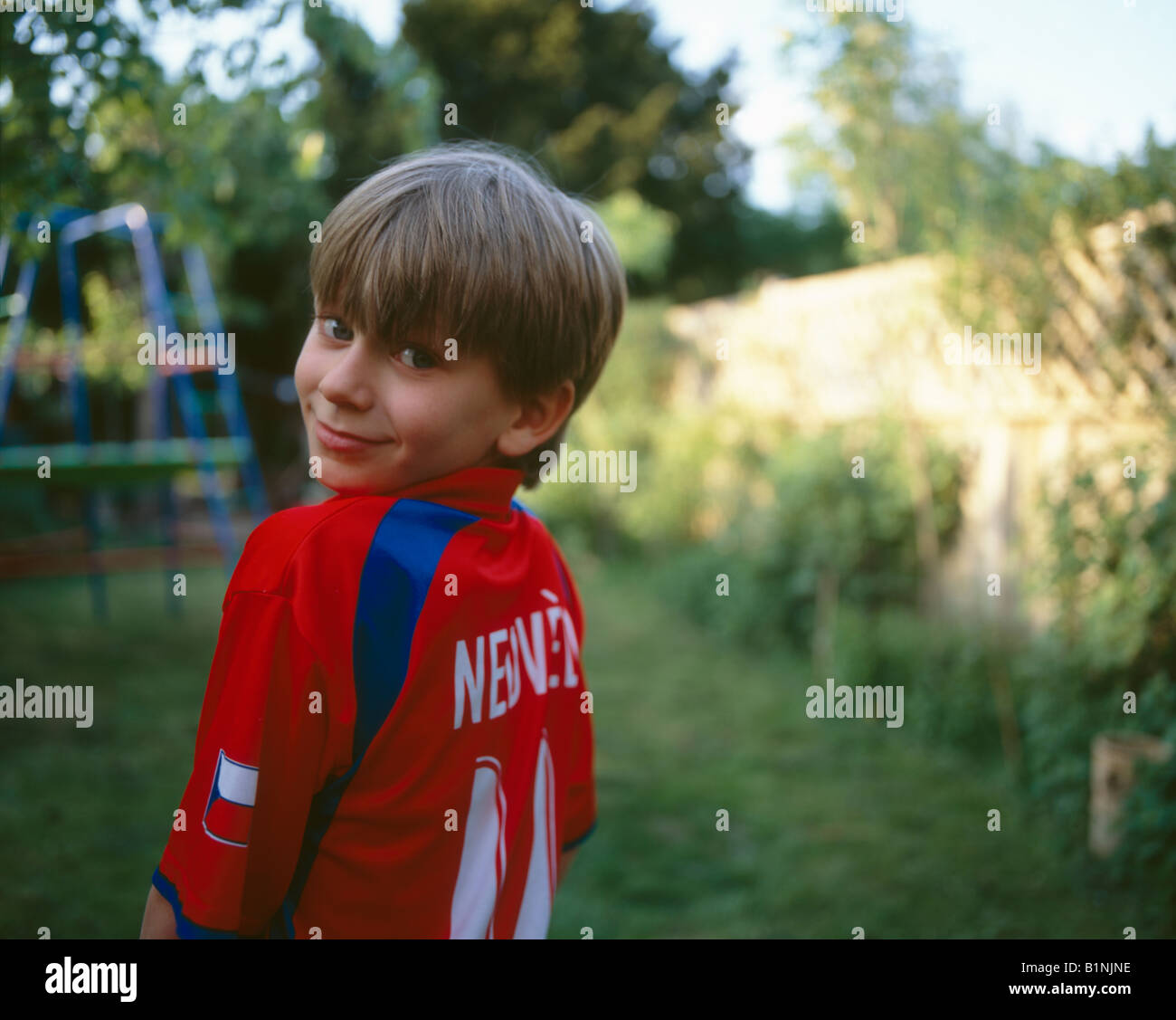 Bambino di otto anni in Czech National kit calcio giocando in inglese giardino estivo Foto Stock