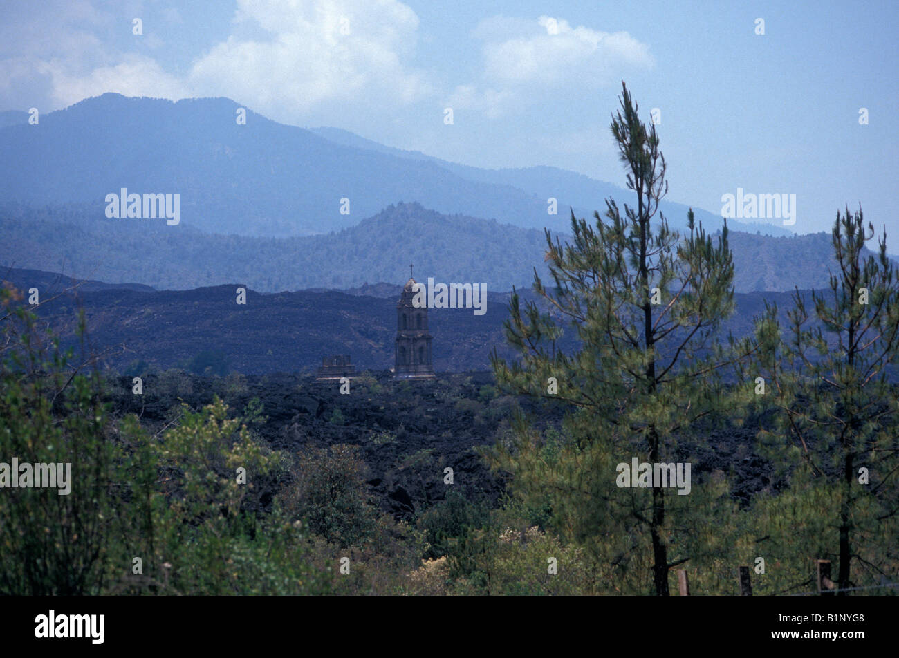 I campi di lava e semi-interrato Templo de San Juan Parangaricutiro chiesa con Volcan Paricutin nel retro, Michoacan, Messico Foto Stock