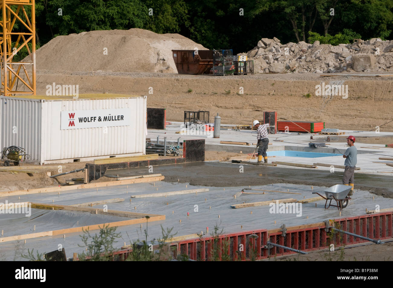 I costruttori lavorano in un cantiere di costruzione gestito da Wolff & Müller, una delle prime dieci aziende di costruzione tedesche, il quartiere Tiergarten di Berlino Germania Foto Stock