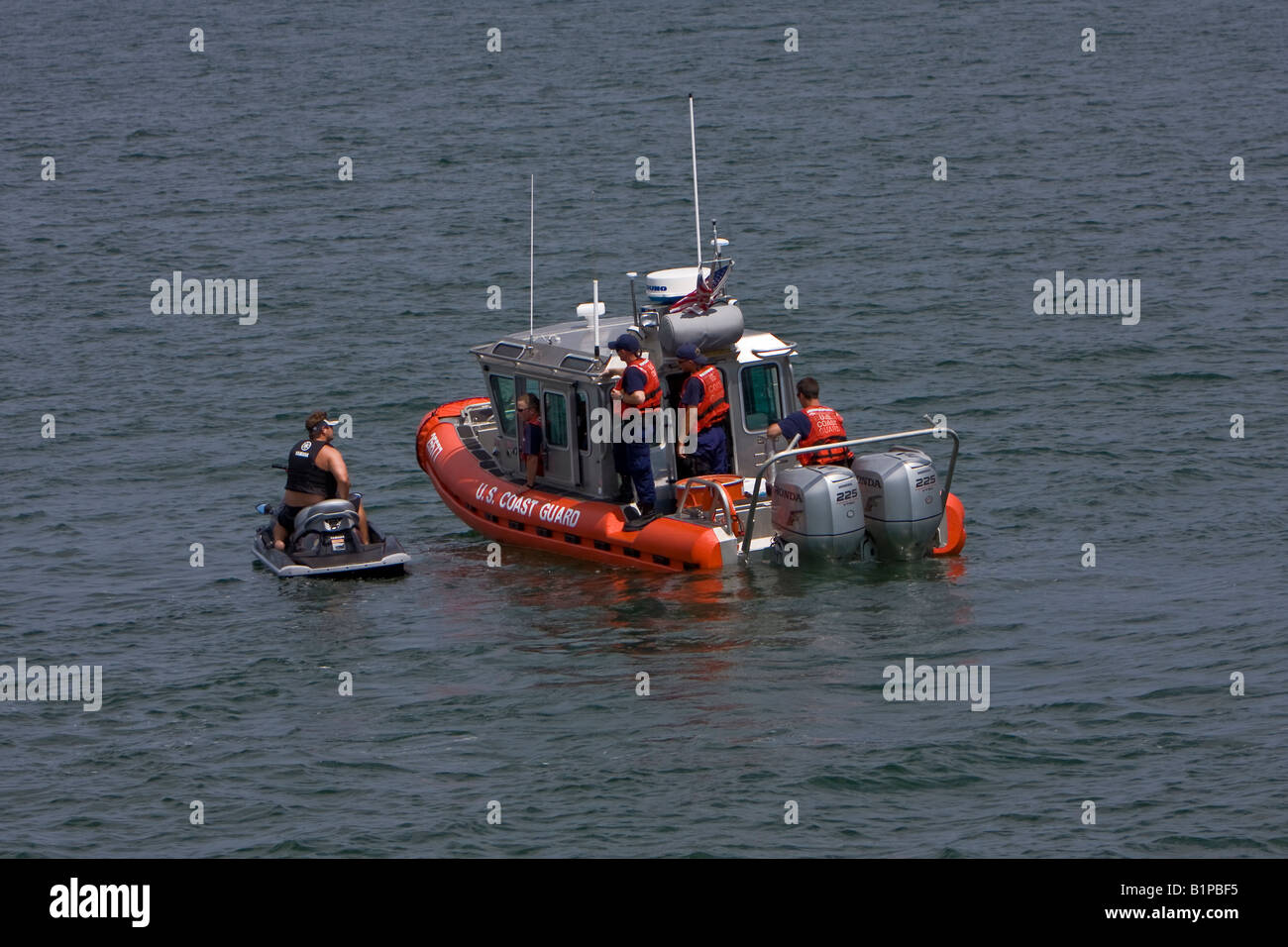 United States Coast Guard Defender classe imbarcazione di pattuglia arresto di un uomo su un natante personale Foto Stock