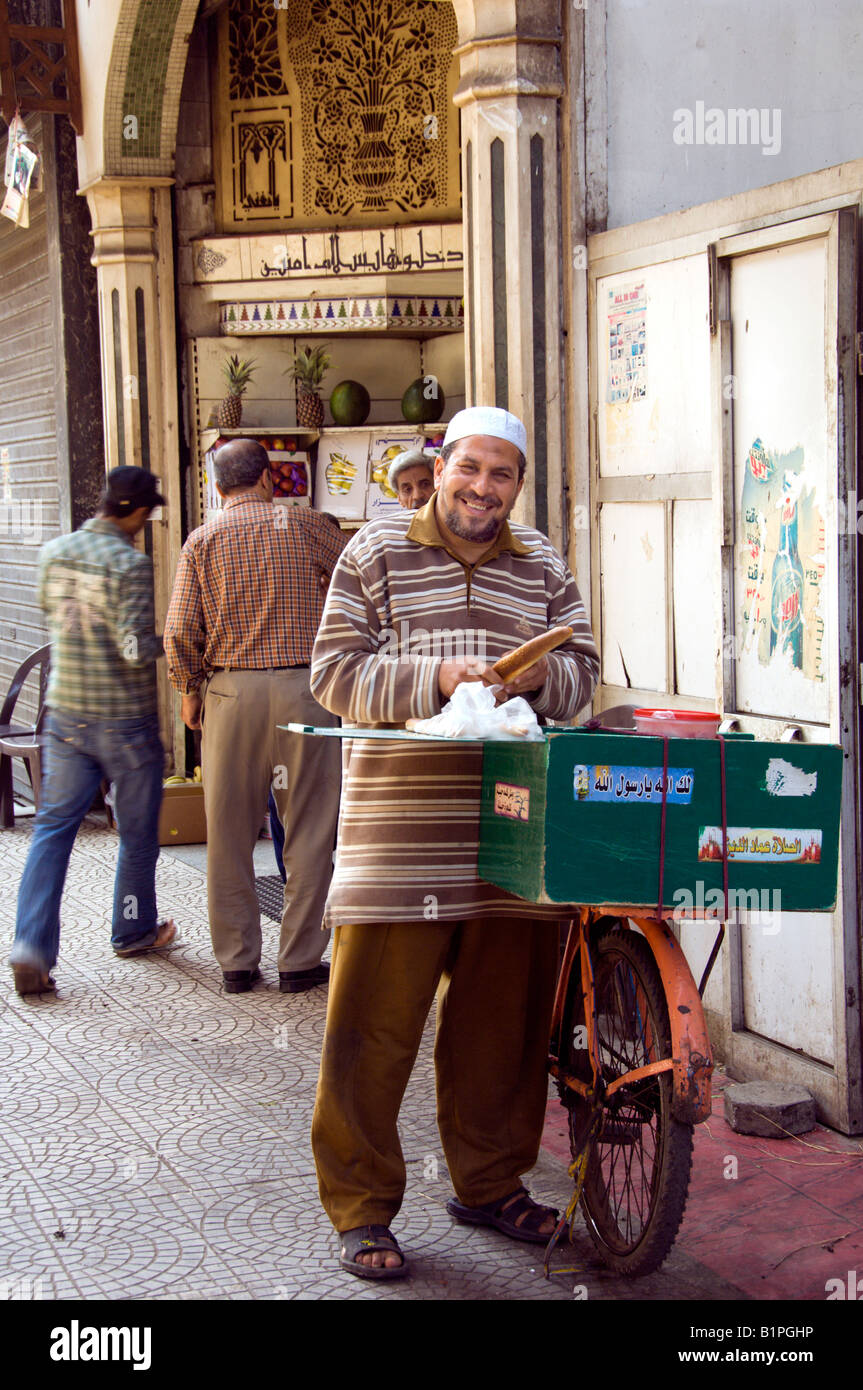 Un sorridente venditore ambulante si prepara a vendere il pane in Zamalek Cairo Egitto Foto Stock