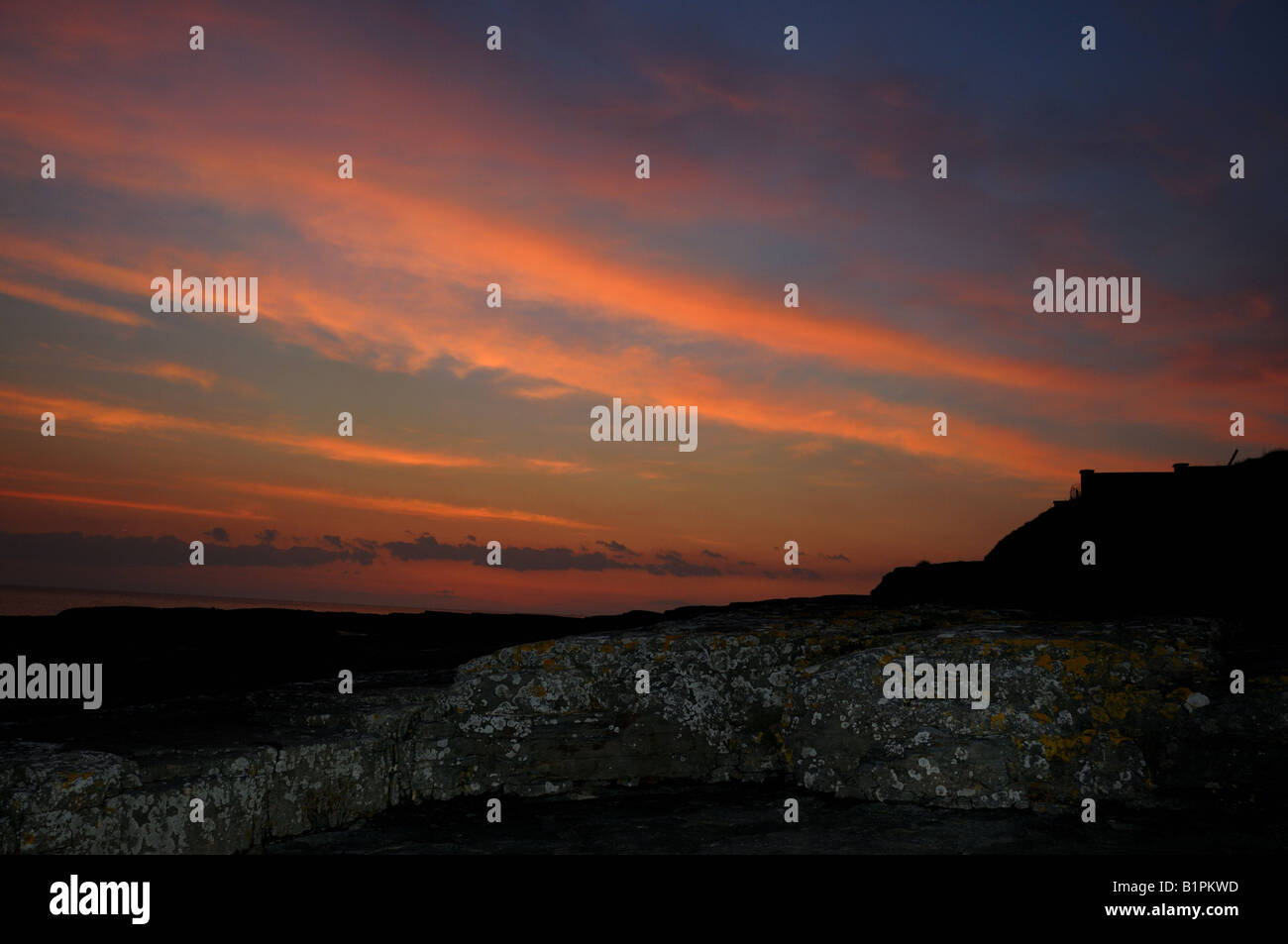 Tramonto dipinge le nuvole colorate sulla costa rocciosa dell'Oceano Atlantico. County Clare, Irlanda. Foto Stock