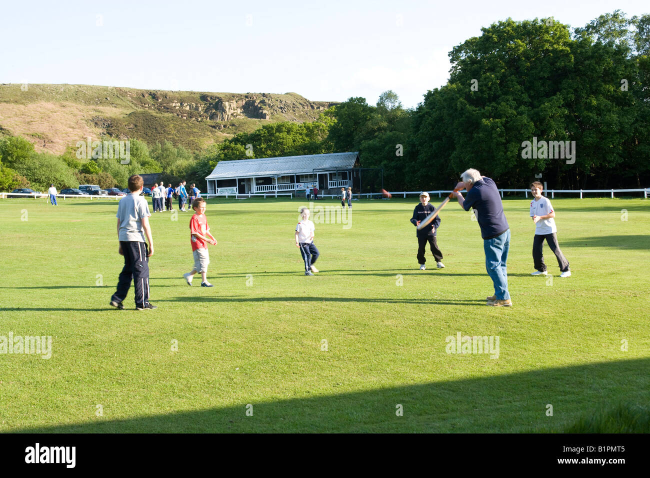 I ragazzi giocare a cricket su un territorio rurale campo da cricket Foto Stock