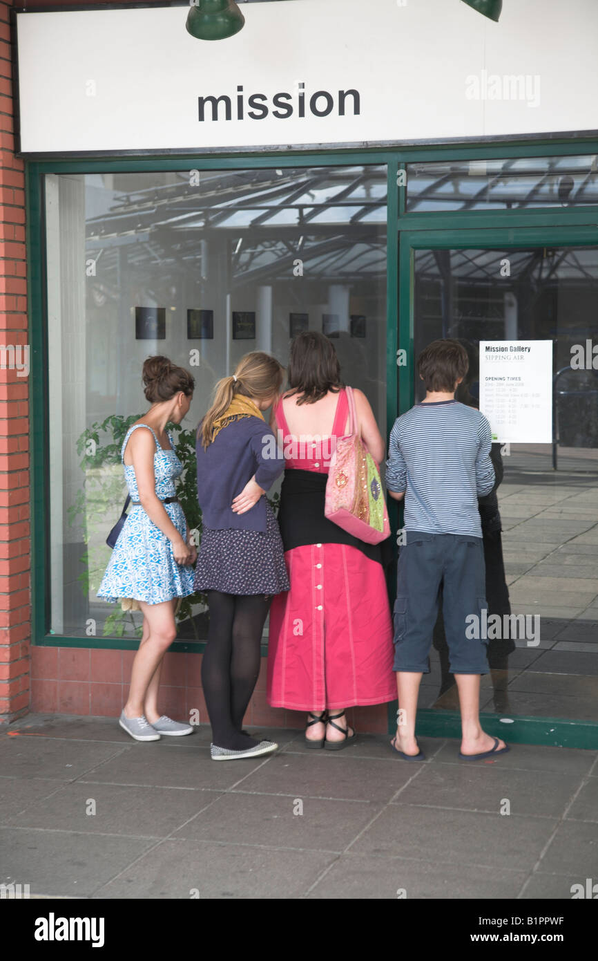 Quattro persone in cerca nella vetrina di chiuso mostra d'arte Foto Stock