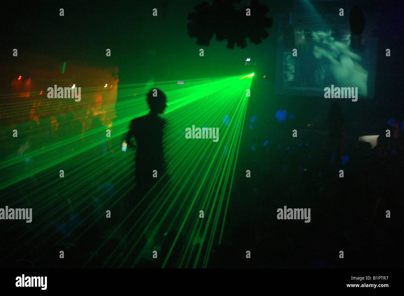 Silhouette di un ballerino maschio in un partito/discoteca con il laser a parte per il suo taglio di silhouette Foto Stock