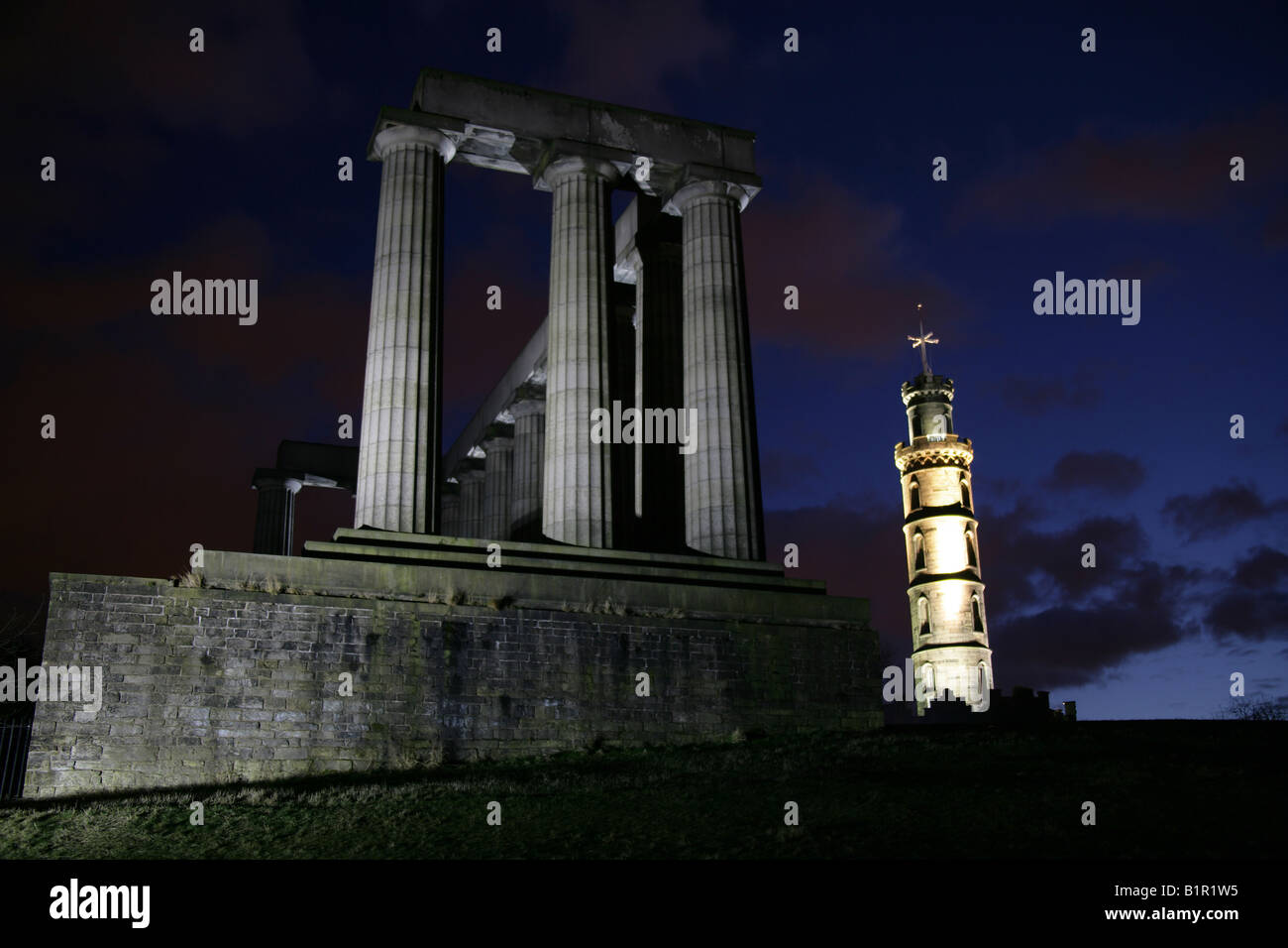 Città di Edimburgo in Scozia. Notte Vista illuminata di Nelson's Monument e il Monumento Nazionale, a Edimburgo di Calton Hill. Foto Stock