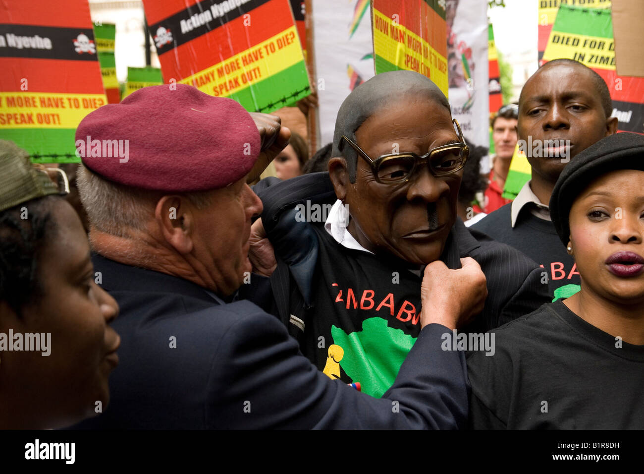 Anti Mugabe manifestanti grab uomo nella maschera di Mugabe al di fuori del Sud Africa House Londra Foto Stock