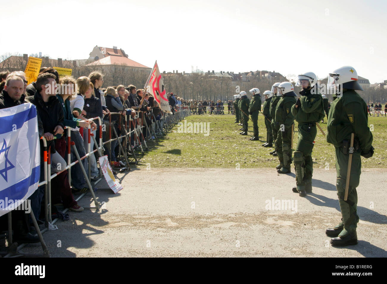 Alcuni manifestanti che protestavano contro un neo-nazi caso in piedi di fronte a una fila di funzionari di polizia, Monaco di Baviera, Germania, Europa Foto Stock