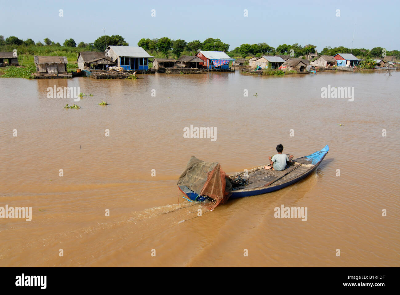 Barca sul fiume Mekong passando un villaggio sulla riva, Batambong, Cambogia, Asia Foto Stock