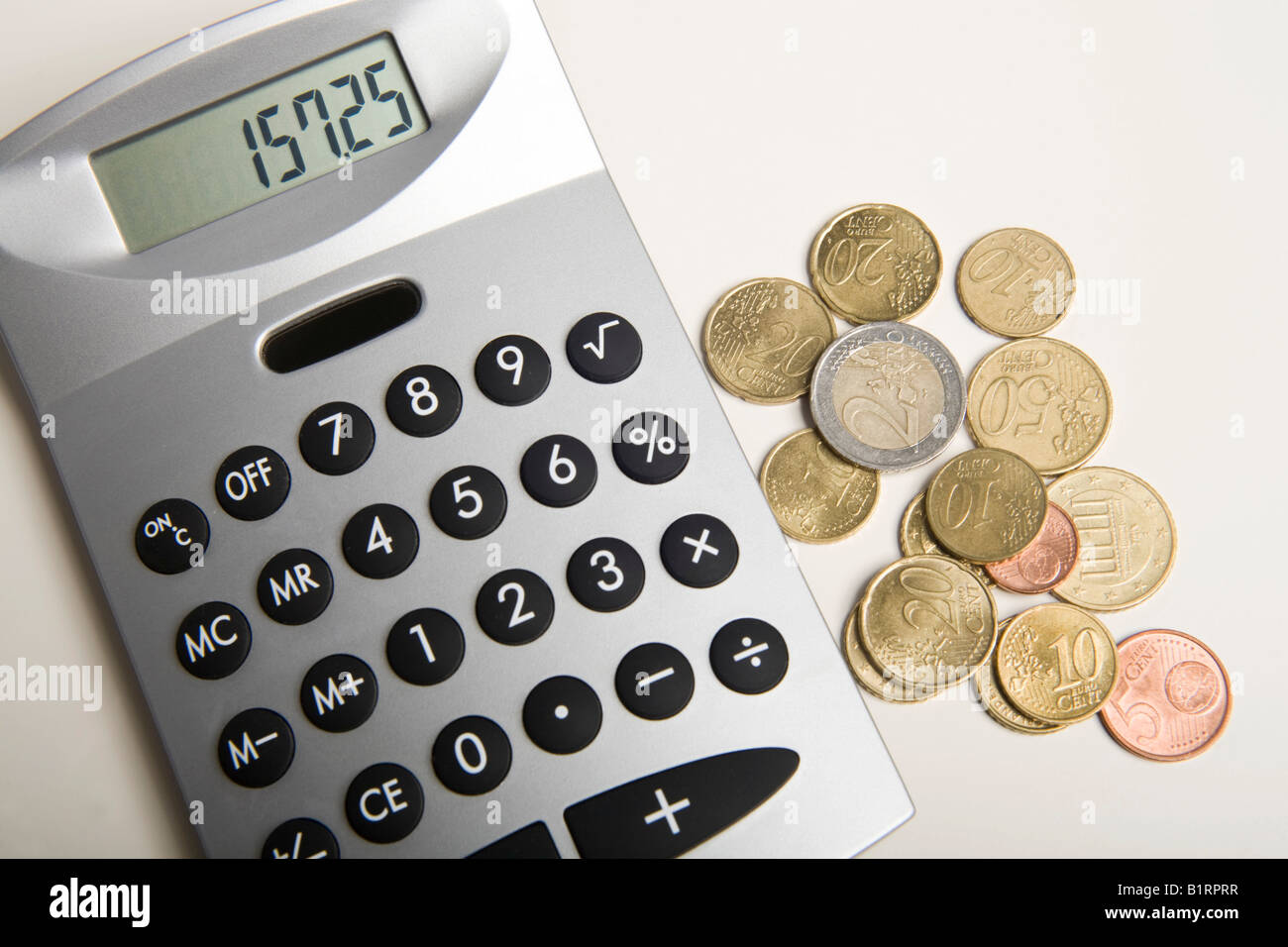 Monete metalliche in euro accanto a una calcolatrice Foto Stock