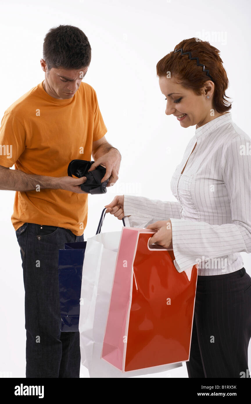 Donna con piena borse per lo shopping, l'uomo con il portafoglio vuoto Foto Stock