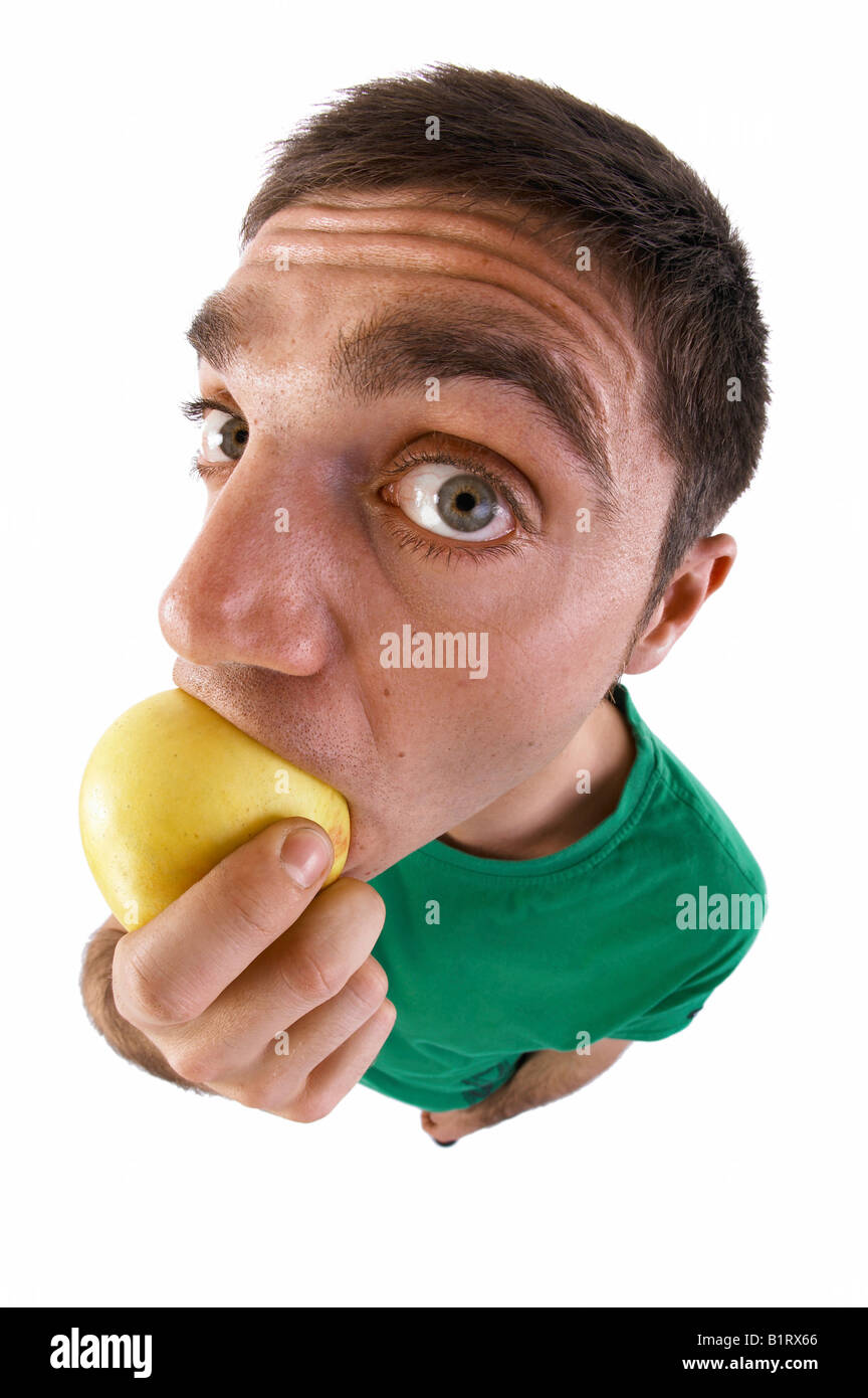 Uomo di mordere in un apple, lente fish-eye Foto Stock