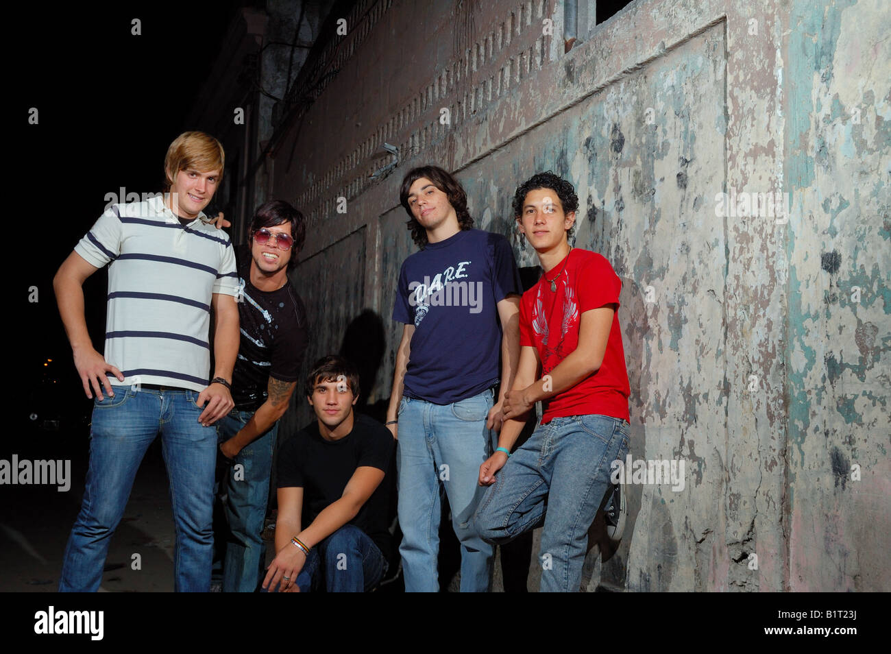 Gruppo Informale di adolescenti in piedi contro la parete di grunge Foto Stock