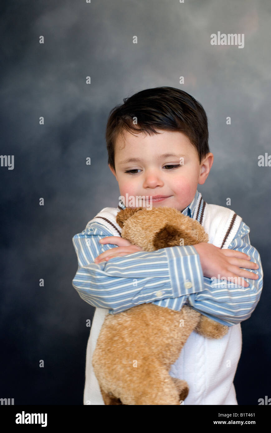 Due e una metà (1/2) anno vecchio ispanico American boy pone con il suo giocattolo preferito, un cane da compagnia Foto Stock