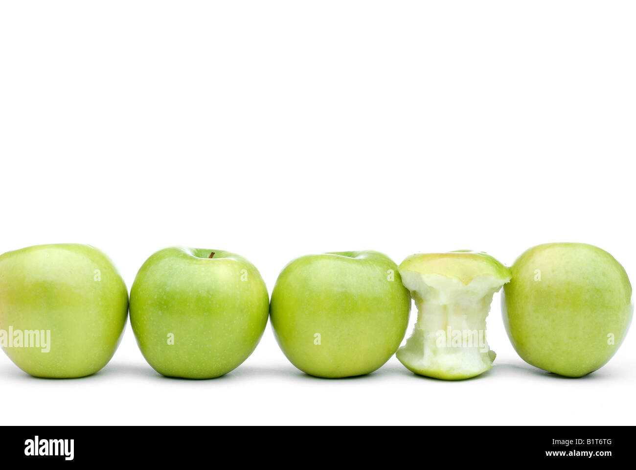 Mele Verdi line up su uno sfondo bianco con una mangiata apple Foto Stock