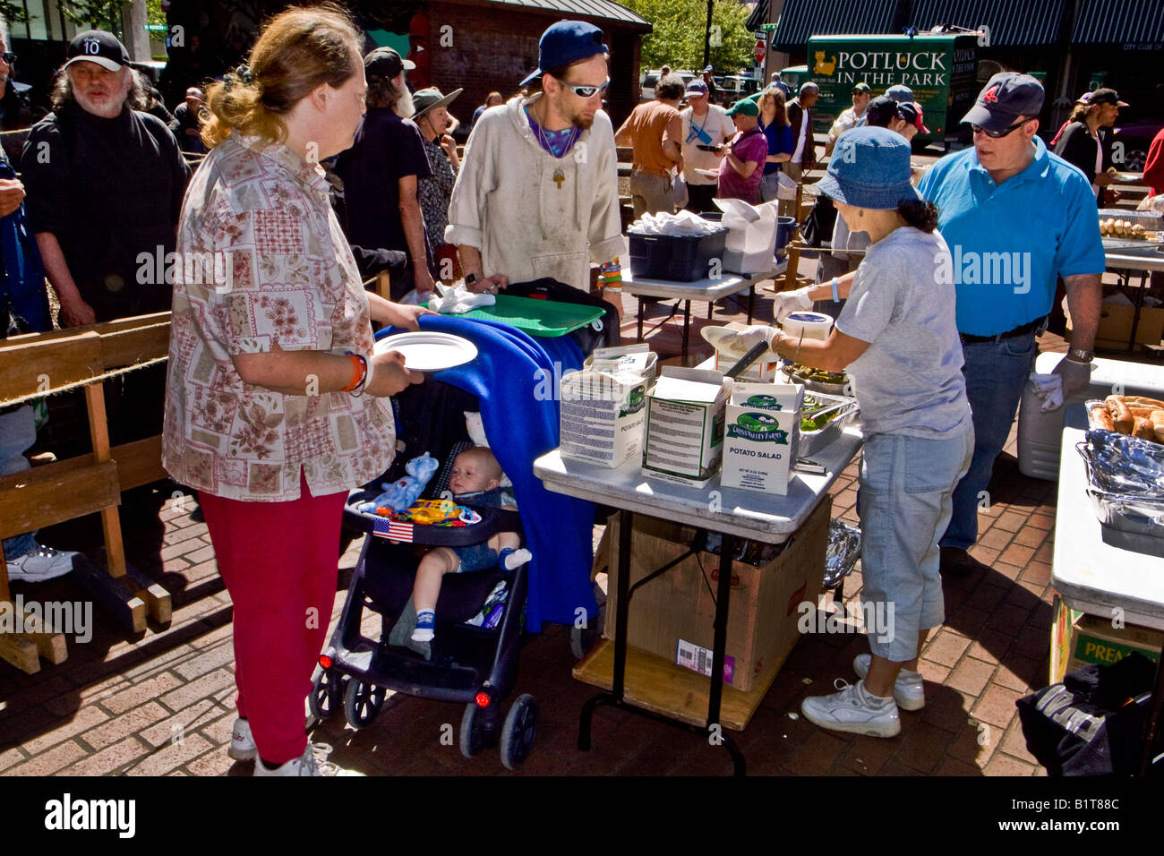 Una famiglia giovane con un bambino unire altre persone senza dimora per una libera per il brunch di Domenica in O Bryant Square Portland Oregon Foto Stock