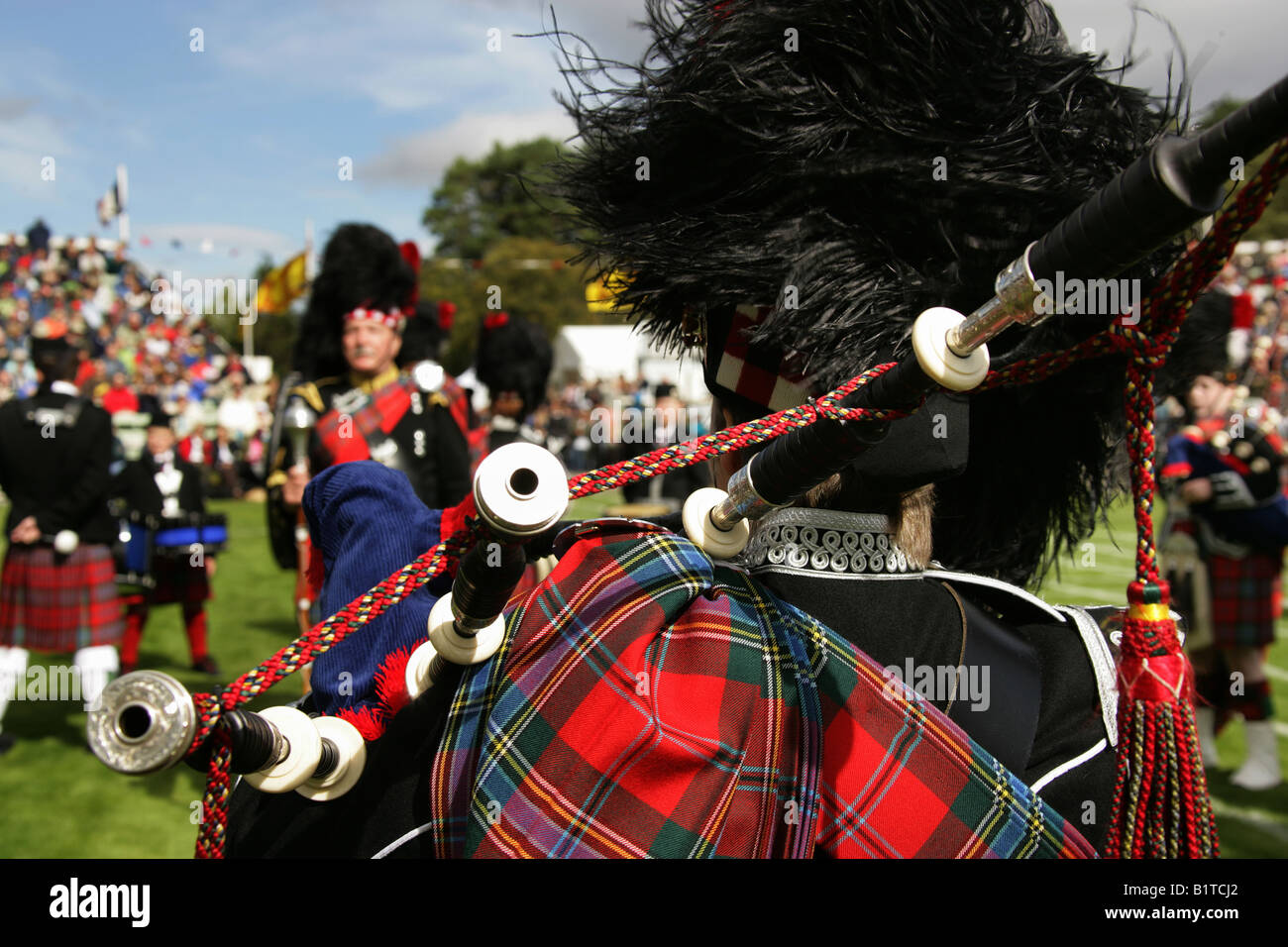 Villaggio di Braemar, Scozia. Vista posteriore di un suonatore di cornamusa scozzese in lizza nella pipe band della concorrenza a Braemar giochi. Foto Stock