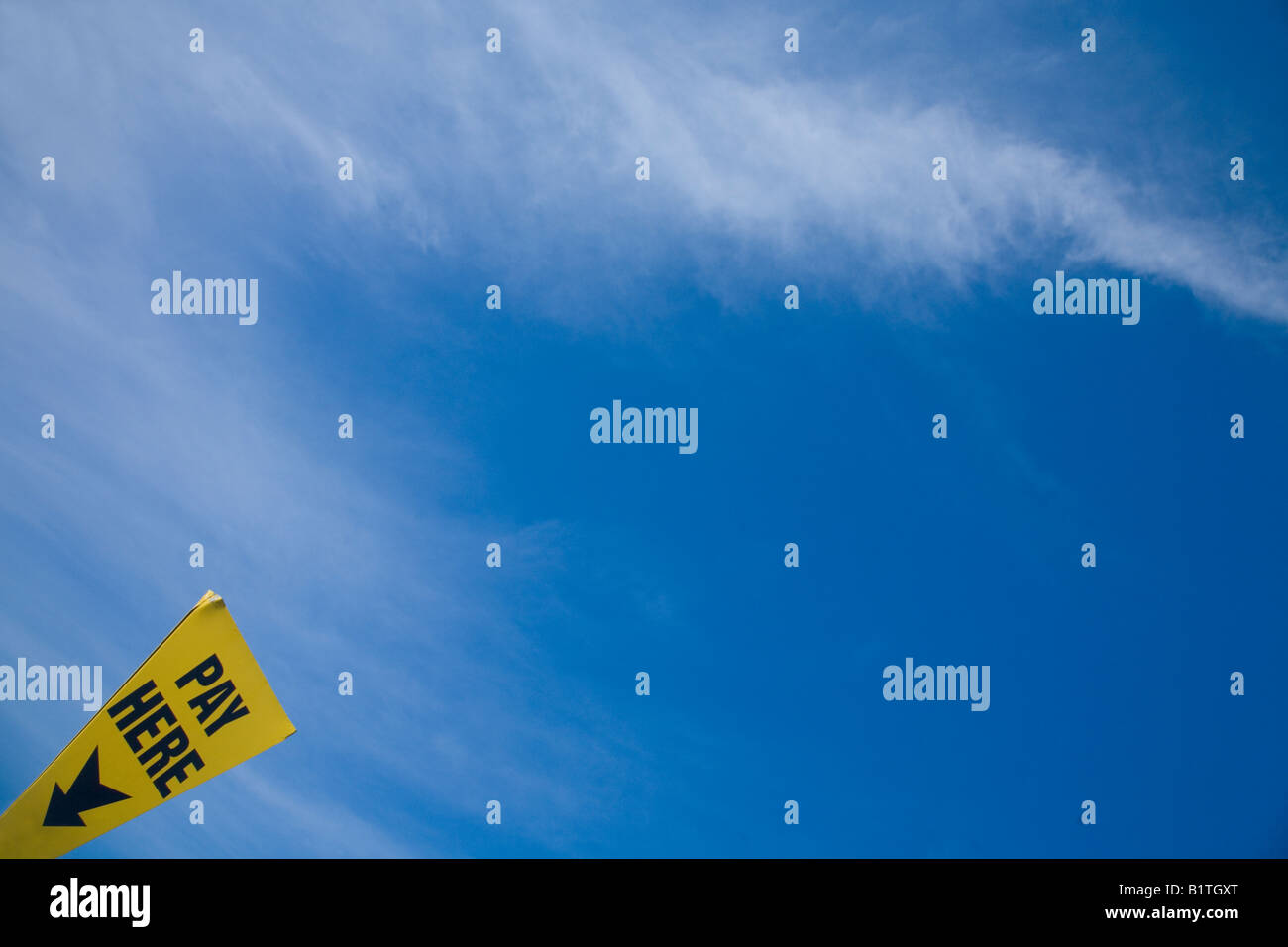 "Pagare qui' segno parcheggio nuovo cielo blu, il bianco delle nuvole per parcheggio auto a pagamento in Inghilterra UK GB Isole britanniche Foto Stock