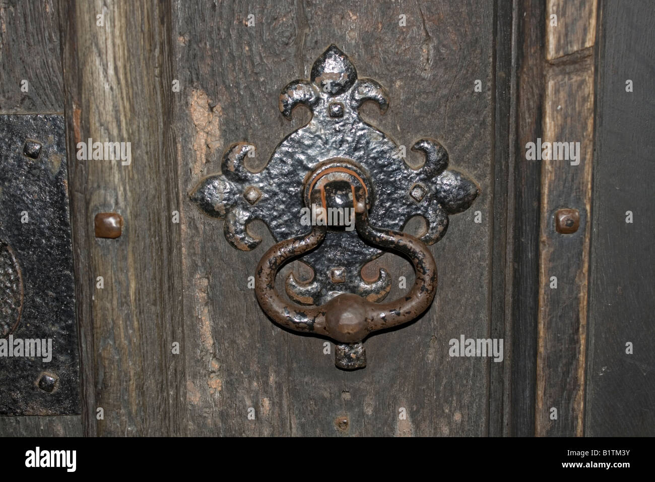 Ferro vecchio maniglia della porta con battuto surround sul porta in legno di quercia di chiesa NORFOLK REGNO UNITO Foto Stock