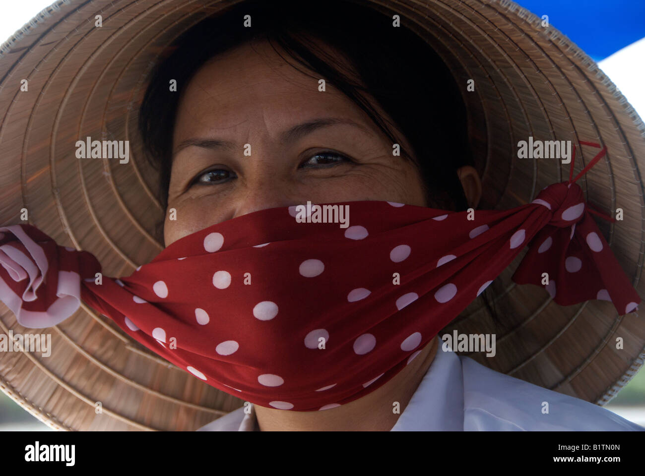 Ritratto donna che indossa cappello conico e la maschera di Cai Rang Mercato Galleggiante lungo il delta del Mekong Il Vietnam Foto Stock