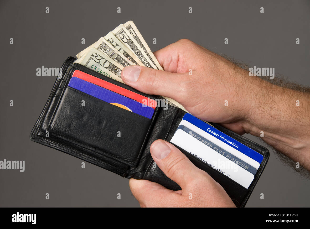 Le incavature in contanti da una custodia in cuoio per pagare le fatture Foto Stock