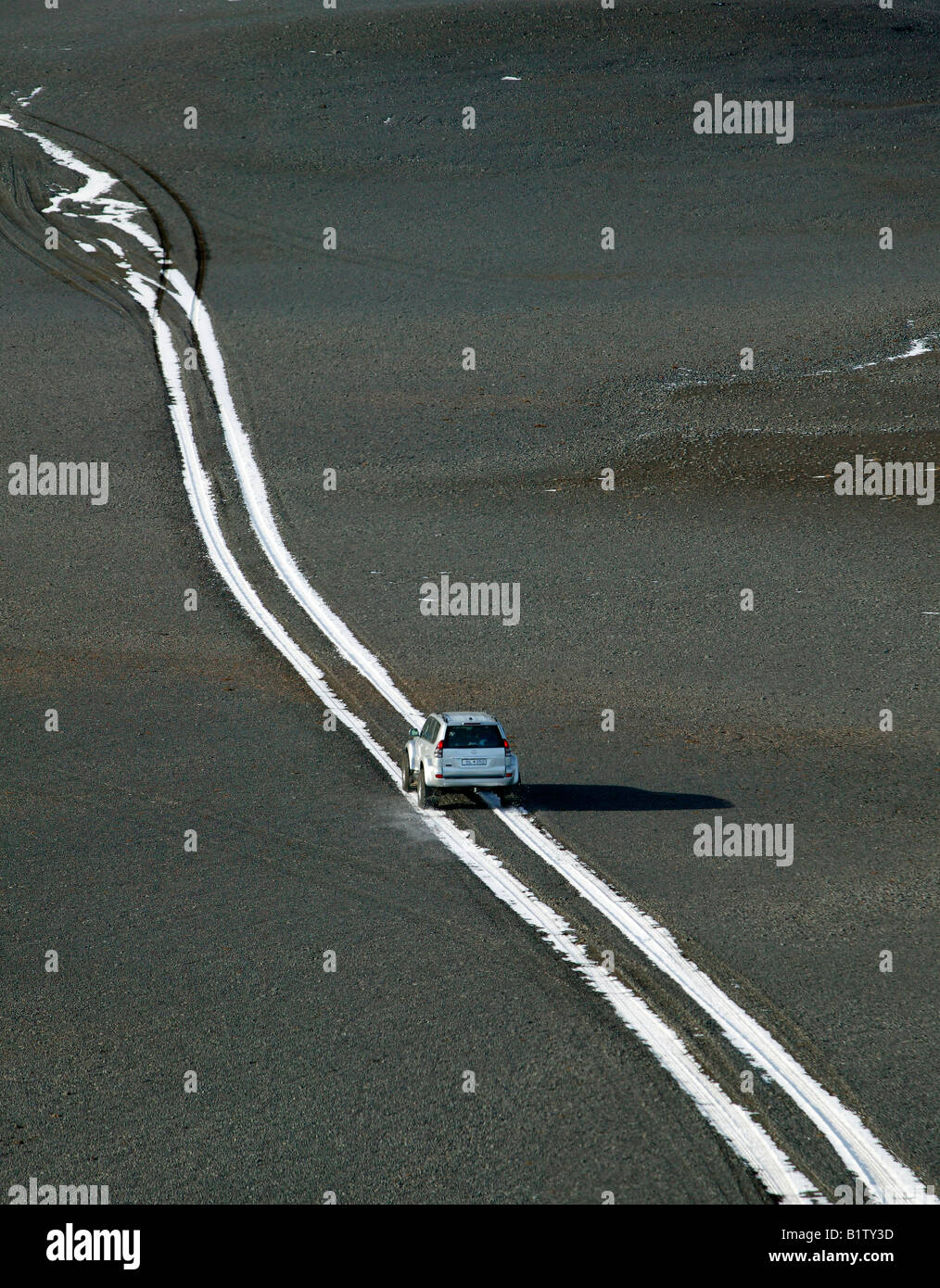 SUV la guida su neve Le tracce sulla strada rocciosa, Islanda Foto Stock