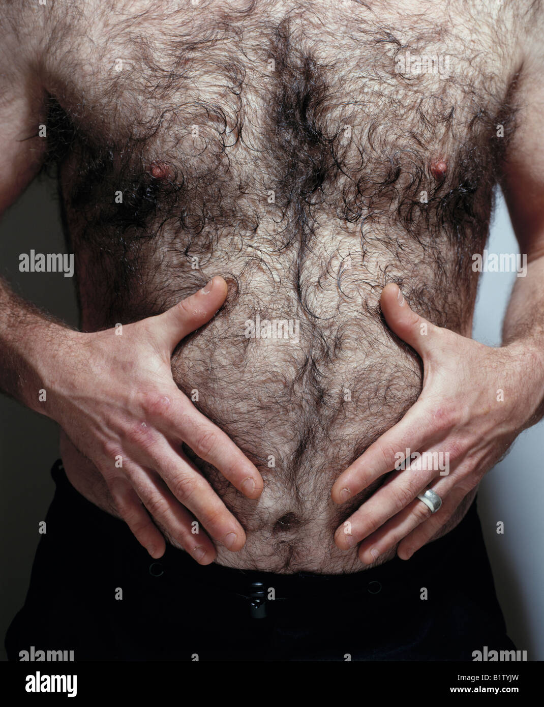 Uomo peloso stomaco di sfregamento Foto stock - Alamy