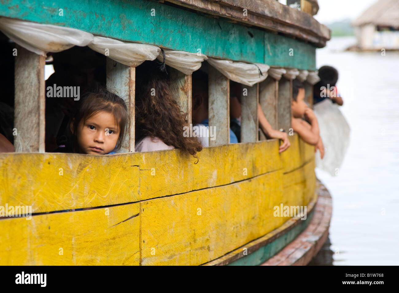 Una giovane ragazza peruviana si siede nel pensiero su un traghetto che è venuto da una giungla cittadina il fiume del Amazon. Foto Stock