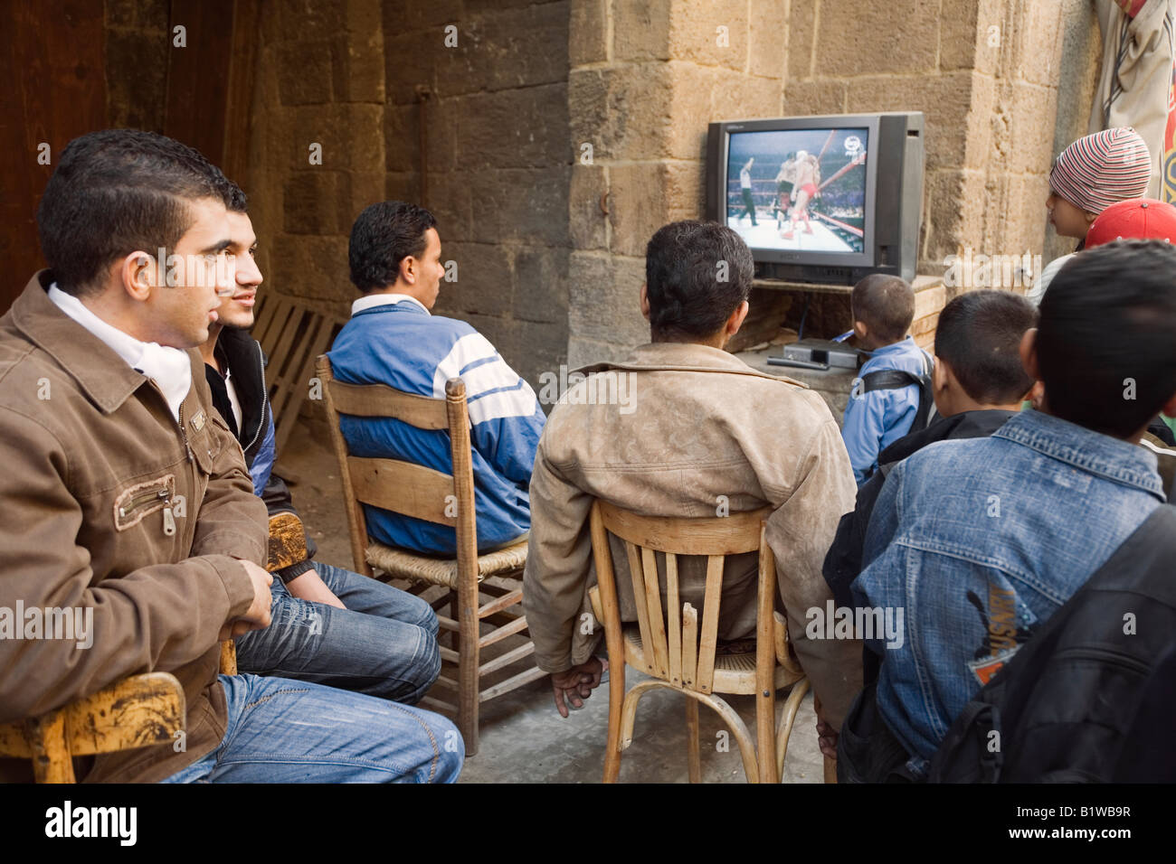 Il Cairo, Egitto, Nord Africa. La gente del posto la visione di North American wrestling sulla televisione ad un outdoor cafe, Khan al Khalili Foto Stock